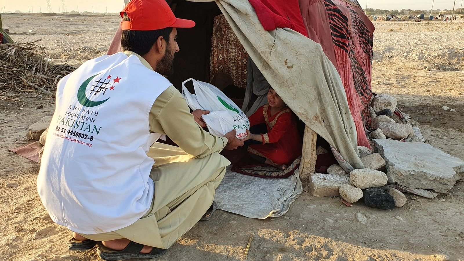 Khubaib Foundation volunteer delivering aid to a child in need.