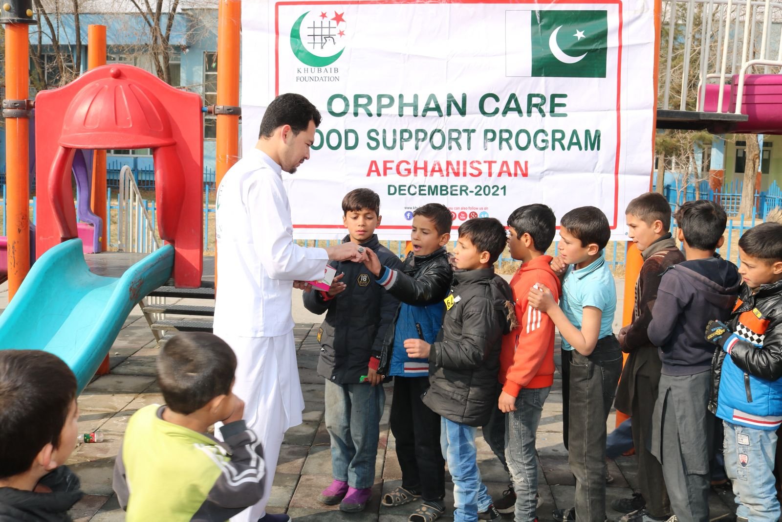 Volunteer distributing aid during the Afghanistan Orphan Care Food Program.