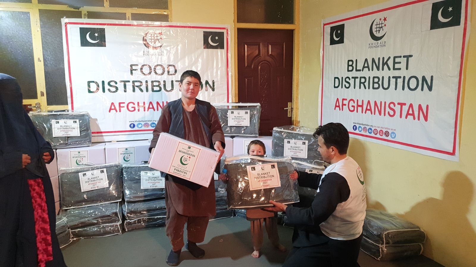 Volunteers distributing blankets and winter relief in a mountainous region.